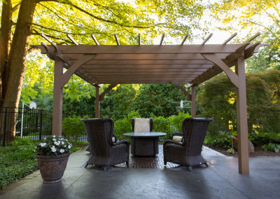 stained concrete patio with stamped brick design under a cedar pergola