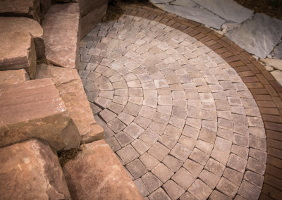 a mix of natural stone and brick pavers set in a decorative patio