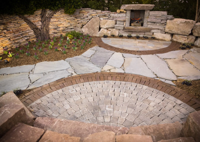 a mix of natural stone and brick pavers set in a decorative patio