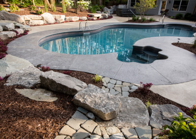 stamped concrete patio around freeform pool, with paver walkways