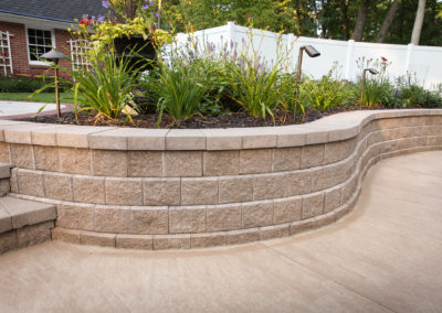 custom concrete pool patio, retaining wall, steps and landscape lighting by essex outdoor design