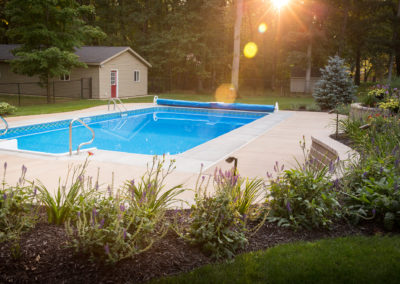 custom concrete pool patio, retaining wall, steps and landscape lighting by essex outdoor design
