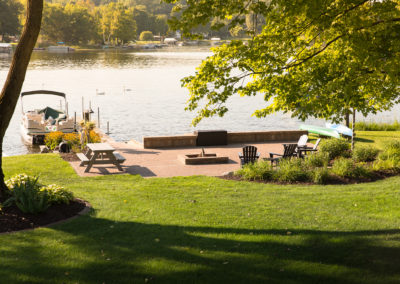 family friendly patio and firepit by the lake landscaped by essex outdoor design
