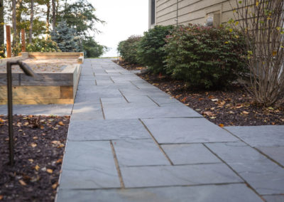 flagstone patios and built in grill overlooking Lake Michigan landscaped by essex outdoor design