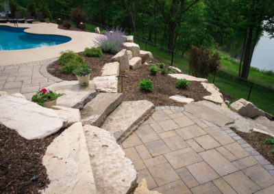 landscape design with boulder steps, pool and natural paver patio by essex outdoor design