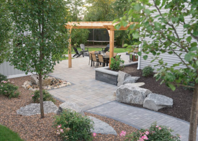 backyard landscaping with shed, hot tub spa, built in bar, pergola and water bubbler by essex outdoor design