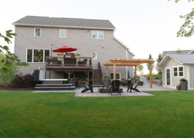 backyard landscaping with shed, hot tub spa, built in bar, pergola and water bubbler by essex outdoor design